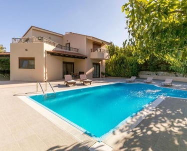 Luxury vacation villa with a large private outdoor swimming pool and sun loungers.
