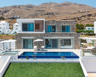 Luxury stone villa in Rhodes with an infinity pool, sun loungers, and scenic mountain views.