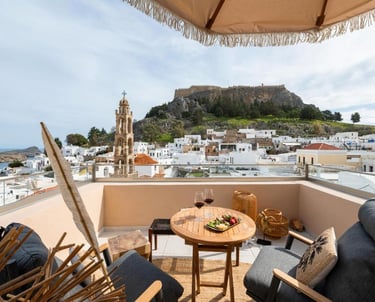 Luxury terrace view in Lindos, Rhodes overlooking the Acropolis and white village houses.