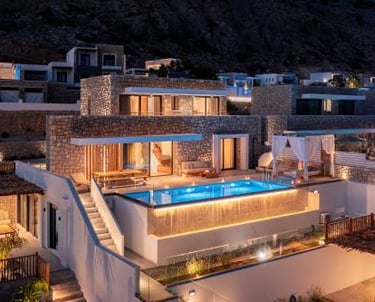 Luxury stone villas at night featuring an illuminated private infinity pool and modern patio.
