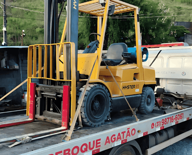 Guincho plataforma da Agatão transportando empilhadeira amarela, fixada com segurança.