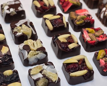 Artisan dark chocolate squares topped with dried fruits and nuts, handcrafted for elegant gifting and