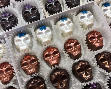 Handcrafted white, milk, and dark chocolates inspired by Day of the Dead featuring festive and traditional designs