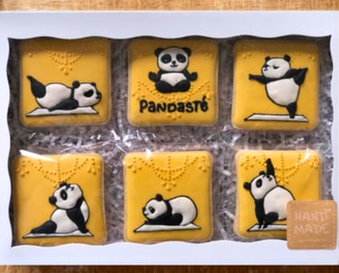 Set of decorated cookies in a box featuring adorable panda-themed, crafted with royal icing, a unique treat for yoga lovers
