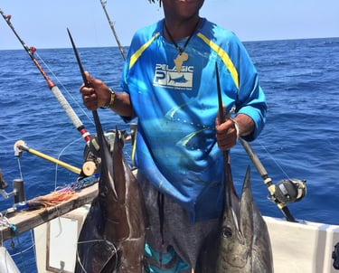 a man holding two fish on a boat