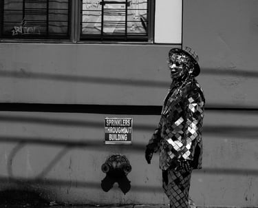 black and white shot of a brooklyn street performer in a metallic mirror costume