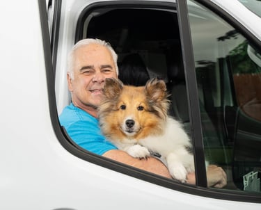 John holding his dog in the service truck