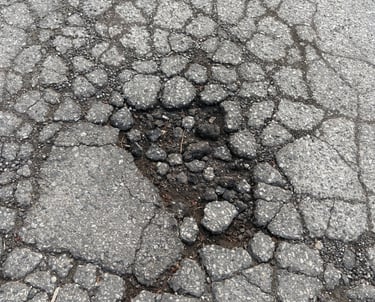 Allegator crack turning into a pothole with major asphalt chipout