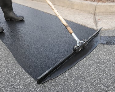 Spreading our high quality emulsion sealcoat product to a parking lot