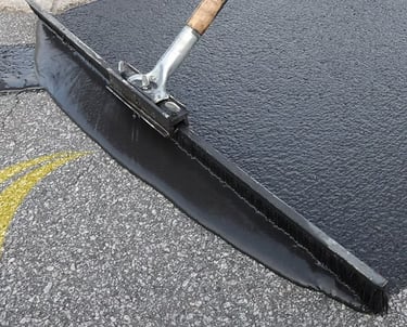 Spreading sealcoat on parking lot repair
