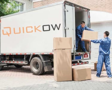 a group of people moving boxes into a moving truck