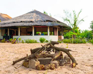 A serene view of the Tamba Kuruba Eco-Lodge, featuring eco-friendly thatched-roof cabins nestled wit