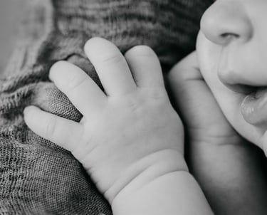Détail en noir et blanc de la bouche et de la main d’un nouveau-né – photo naissance Gard