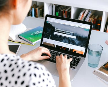 A woman sitting at a desk with a laptop computer