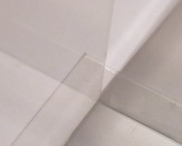 An illusion of multiple spaces created by two clear plastic sheets meeting. 