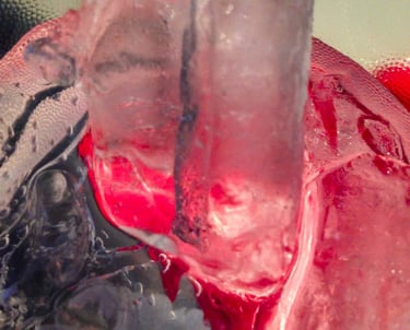 Several melting ice cubes of different sizes and shapes, in a plastic clear cup.