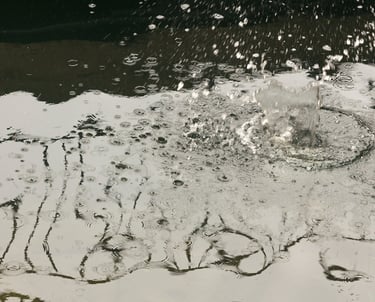 Monochromatic body of water reflecting a steel railing.