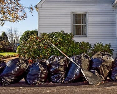 Image of a stack of garbage bags outside a house from cleanup