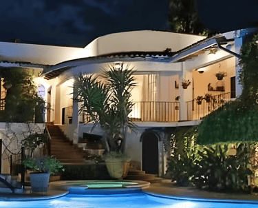 a magnificent villa with a pool and terraces at night