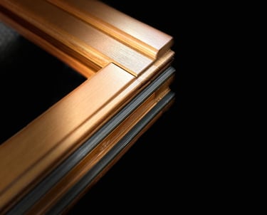 Close-up of a modern copper aluminum window frame corner with black thermal insulation.