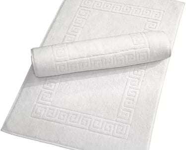 White cotton bath mat set with Greek key border pattern and rolled towel mat