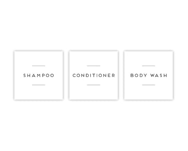 a white bathroom with a white wall and a black and white sign