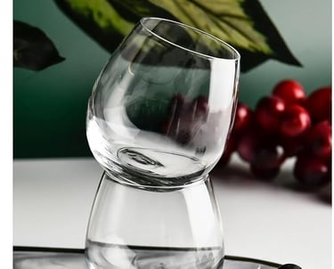 a glass of wine on a tray with grapes and grapes