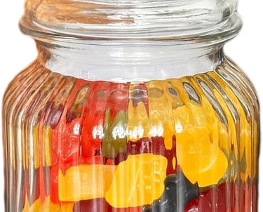 A clear ribbed glass apothecary jar filled with colorful gummy bears on a white background.