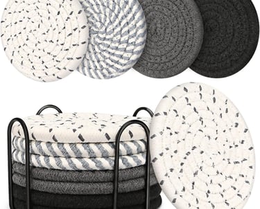 a stack of four round coasters with a black and white pattern