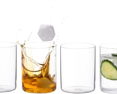 a glass of alcohol with a slice of cucumber on the side