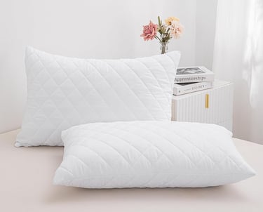 a pair of pillows and pillows on a bed