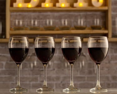 three wine glasses with wine glasses on a bar