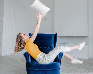 a woman sitting in a chair with a pillow and pillow