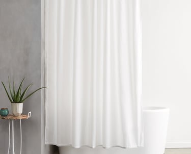 a white shower curtain with a plant in a bathroom