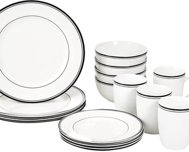 a set of white dinnerware with black and white stripes