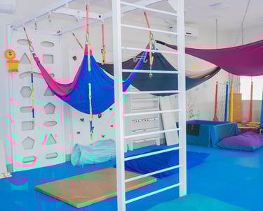 Espaço lúdico e pedagógico da Clínica Integrar 2, com piso macio e equipamentos de estímulos