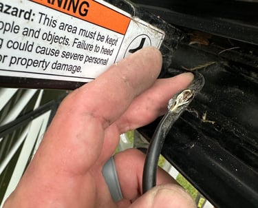 a person holding a piece of metal wire with a cut