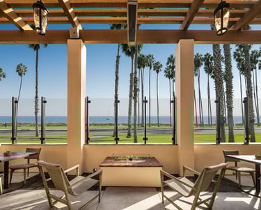 Hilton Santa Barbara Beachfront Resort outdoor lounge with palm trees and ocean view