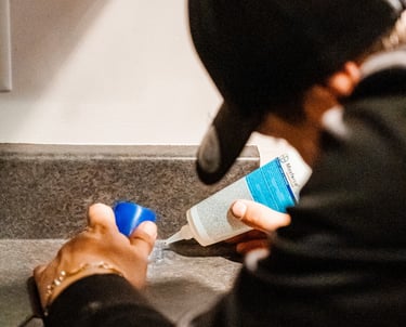 a man in a black jacket is holding a bottle of liquid