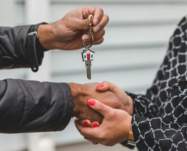 Key handover between two people representing mortgage approval and homeownership