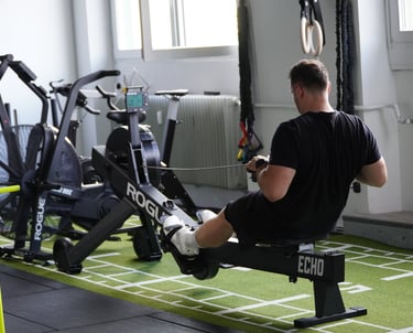Mann sitzt auf Rudergerät im Gym