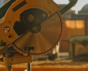 Scie pendulaire et poutres en bois prêtent à être débitées