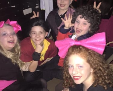 a group of kid actors posing for a picture backstage connecting as friends.