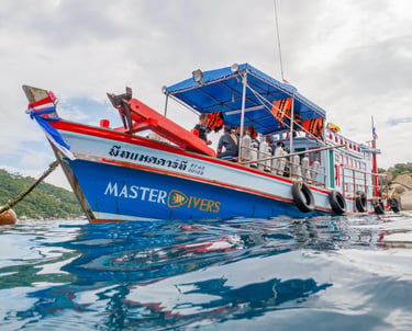 A Master Divers scuba diving boat anchored in the tropical blue waters of Koh Tao, Thailand.