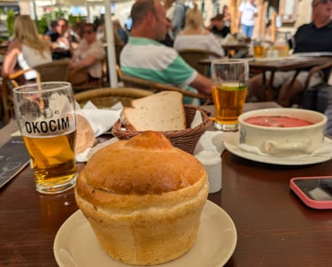 a table with a Żurek w chlebie and beer in a restaurant