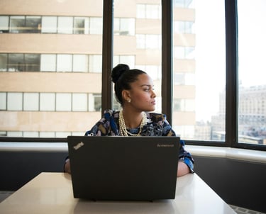 a woman sitting at a table with a laptop