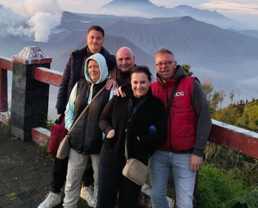 Sekeluarga tourism dari Belanda sedang berpose dengan latar belakang gunung Bromo.