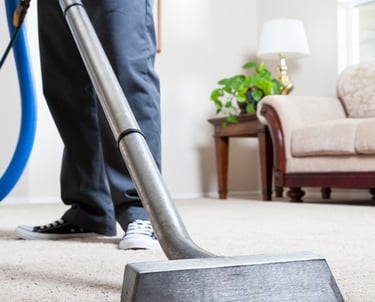 a man is cleaning a carpet with an extractor wand