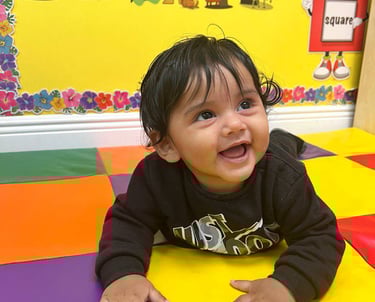 a baby in a play area with a colorful play mat FANTASTIC LAND LEARNING CENTER