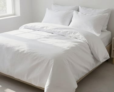 A crisp, neatly made bed with high-quality linens in a sunlit, minimalist room.